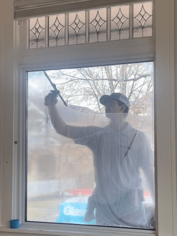A professional window cleaner is cleaning a window.